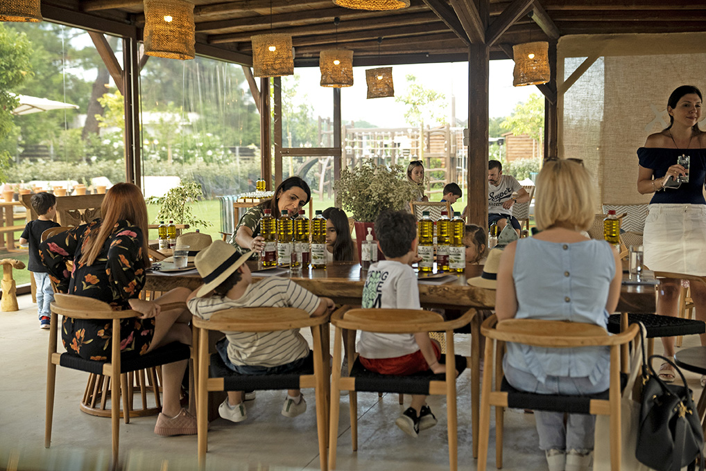 4 mothers and their childs sitting in a table with our products